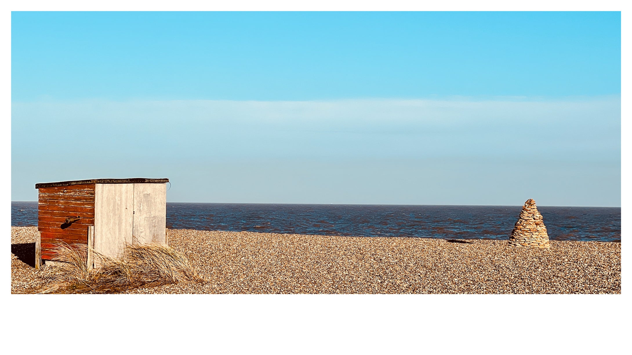 Little beach hut & stone pyramid in Aldeburgh, Suffolk